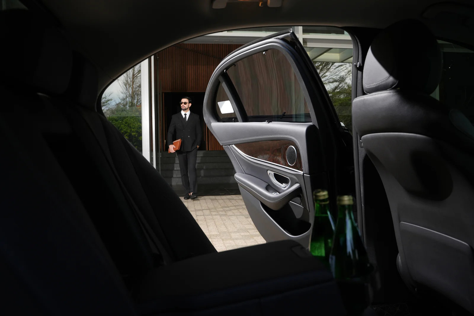 Professional chauffeur opening a premium car door for a guest